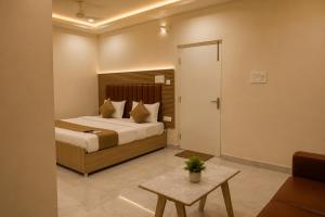 a hotel room with a bed and a table at Hotel Vaarahi Chanda Nagar, Near Hitech City in Hyderabad