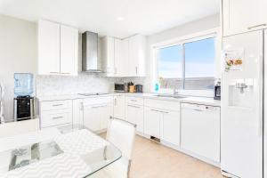 a white kitchen with a glass table and a window at Wonderful house in Niagara-on-the-Lake