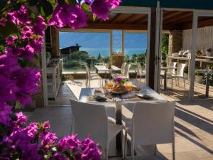 a table and chairs on a patio with purple flowers at La Cascata Negli Ulivi in Toscolano Maderno