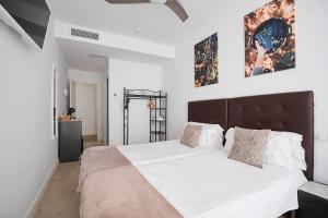 a bedroom with a large bed with white sheets and pillows at Hostal Puente de Hierro in Logroño