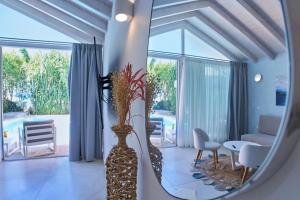 a living room with a vase with flowers in it at Ibiscus Corfu Hotel in Roda