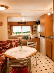 a small kitchen with a table and a living room at Chatka w środku lasu in Czerwona Wola