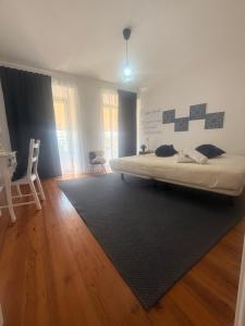 a bedroom with a bed and a rug on the floor at Bogage Boutique House in Setúbal