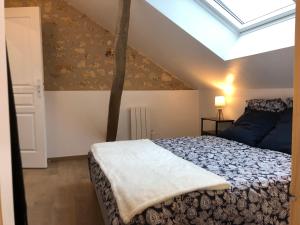 a bedroom with a bed and a skylight at Gîte 4 personnes in Brantôme