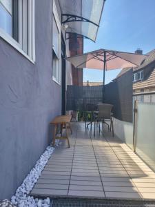 a patio with a wooden table and an umbrella at Casa Sole in Murg