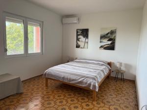 a bedroom with a bed and a window at Pink Holiday House Sutomore in Zankovići