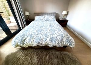 a bedroom with a bed with a floral comforter at Oak Lodge in Hambledon