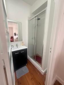 a bathroom with a glass shower and a sink at Bogage Boutique House in Setúbal