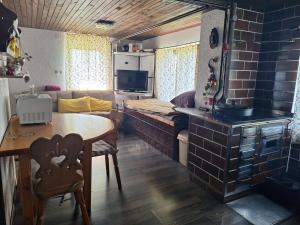 a living room with a table and a room with a couch at David Linea House in Volavlje