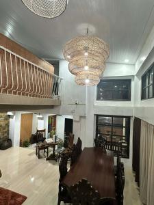 a dining room with a table and a chandelier at A.C. Asistin Transient House in Baguio