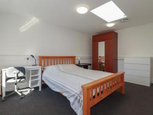 a bedroom with a bed and a desk and a chair at Newseal House in St Austell