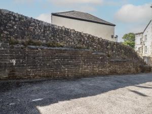 a brick wall with a building behind it at Newseal House in St Austell