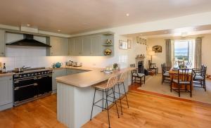 a kitchen with a kitchen island and a dining room at Hollins Farmhouse in Leyburn