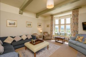 a living room with a couch and a table at Hollins Farmhouse in Leyburn