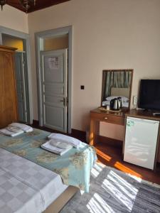 a room with two beds and a desk and a television at Ali Paşa Konağı Sarıyer in Sarıyer