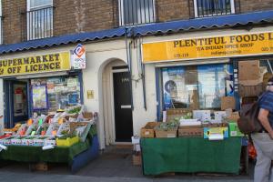 a man standing in front of a fruit and vegetable store at Cosy Private Bedrooms in Euston Station in London