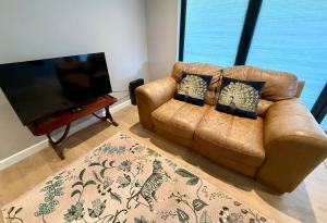 a living room with a couch and a flat screen tv at Oak Lodge in Hambledon