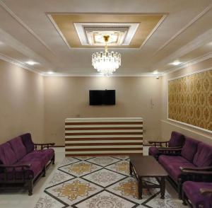 a waiting room with purple couches and a tv at Sheki Villa boutique in Sheki