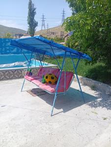 a swing bed with a blue canopy in a backyard at Дом in Shorzha