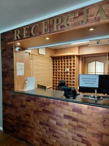 an office with a reception desk with a sign that reads rebecca at Jantar Resort in Szczecin