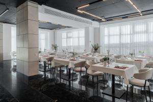 a dining room with white tables and chairs at Azamra in Uman