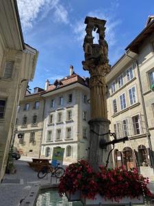 a pole with flowers in front of a building at Cosy studio dans un quartier animé et pittoresque in Fribourg +2 photos