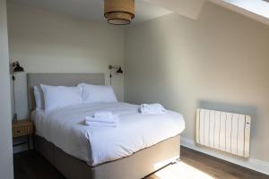 a bedroom with a bed with towels on it at The Yard Dungarvan in Dungarvan