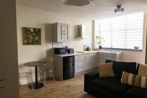 a living room with a couch and a kitchen at The Yard Dungarvan in Dungarvan +22 photos