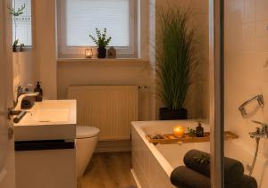 a bathroom with a tub and a toilet and a sink at Gästezimmer Eifelglück - ohne Küche in Pelm