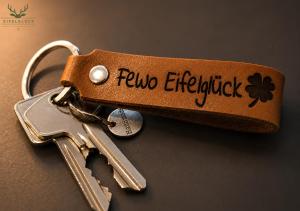 a pair of keys on a keychain with a flower on it at Gästezimmer Eifelglück - ohne Küche in Pelm