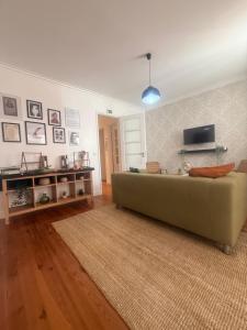a living room with a couch and a flat screen tv at Bogage Boutique House in Setúbal