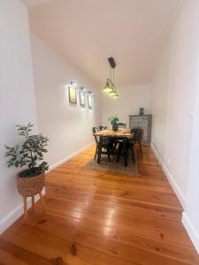 a dining room with a table and a potted plant at Bogage Boutique House in Setúbal
