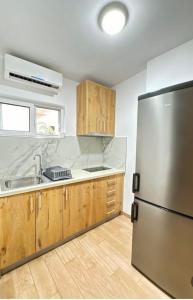 a kitchen with a stainless steel refrigerator and wooden cabinets at Gregor Villa in Asim Zeneli +9 photos