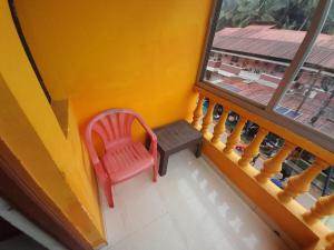 a red chair sitting on a balcony with a window at Dmello guesthouse in Palolem