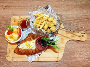a wooden cutting board with a sandwich and french fries at Energy Inn in Taipei