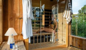 a woman sitting in a window of a sauna at The Sanctuary at Bayside Glamping in Marion Bay +44 photos