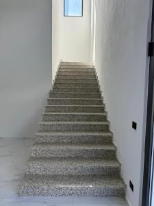a stairway in a building with a stair case at Merlis Hotel in Kusarth