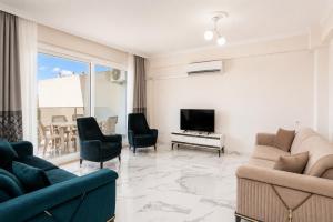 a living room with a couch and chairs and a tv at Villa Azalea 2 in Ortaca
