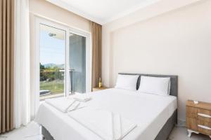 a bedroom with a white bed and a large window at Villa Azalea 2 in Ortaca +9 photos