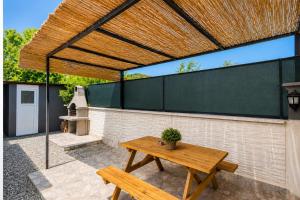 a patio with a wooden picnic table and a fence at Villa Azalea 2 in Ortaca