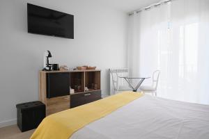 a bedroom with a bed with a television on the wall at Hostal Puente de Hierro in Logroño