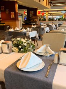 a table with plates and napkins on top of a restaurant at Ida Hotel in Marmaris