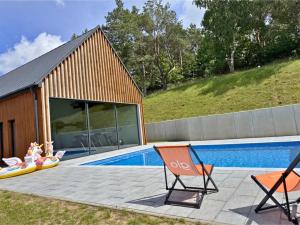 a couple of chairs sitting next to a swimming pool at Domek Reset Kaszuby - Basen, Jacuzzi, Sauna, Siłownia in Łączyno