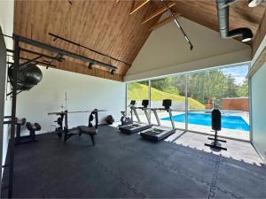 a gym with treadmills and a swimming pool at Domek Reset Kaszuby - Basen, Jacuzzi, Sauna, Siłownia in Łączyno