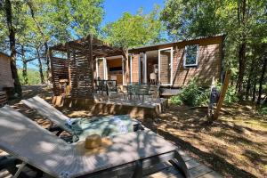 a log cabin with a table and a patio at Camping la Clémentine in Cendras