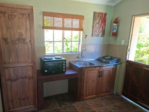 a kitchen with a sink and a microwave at Korentepoort Dam in Riversdale