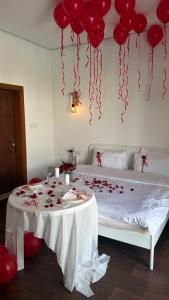 a room with a table with red balloons and a bed at Mykonos Resort in Abu Dhabi +18 photos