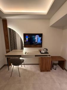 a room with a television on a desk with a chair at Ida Hotel in Marmaris