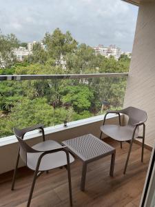 two chairs and a table on a balcony with a window at Millennium Hotel in Nashik