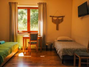 a bedroom with a bed and a desk and a window at Willa Rudy in Stronie Śląskie
